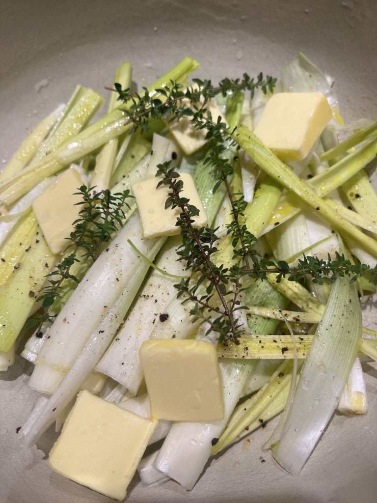 Fresh thyme and sliced leeks being prepared for a simple leek pasta recipe.